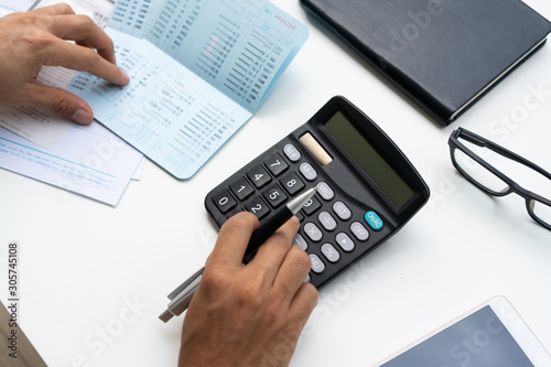 Man using calculator with doing finance at home office.