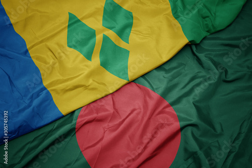 waving colorful flag of bangladesh and national flag of saint vincent and the grenadines.