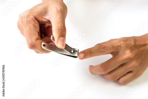 Closeup of a woman cutting nails, using nail clipper, health care concept.