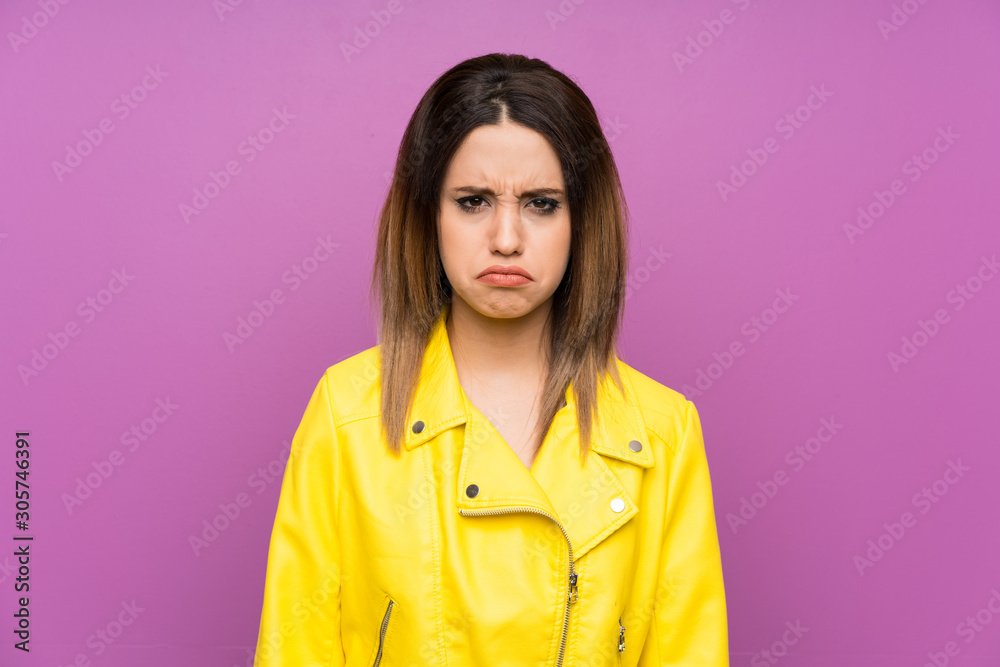 Young woman over purple background sad Young woman over purple background sad