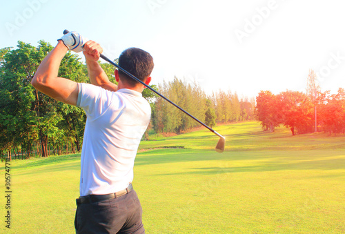 The male golf player on the competition field Start playing golf ball On the green lawn background