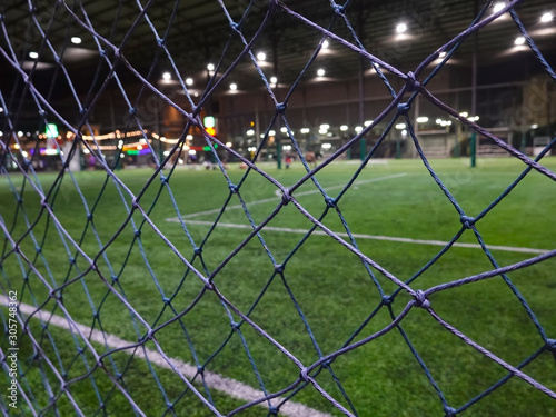 Blurred and selective focus of indoor soccer field on holiday at night time 