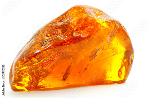 Beautiful transparent piece of amber on a white background. Natural mineral from fossilized ancient resin of wood. Sun stone yellow from of pitch. A piece of digging stone. Magic drawing. Crystal photo