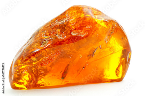 Beautiful transparent piece of amber on a white background. Natural mineral from fossilized ancient resin of wood. Sun stone yellow from of pitch. A piece of digging stone. Magic drawing. Crystal