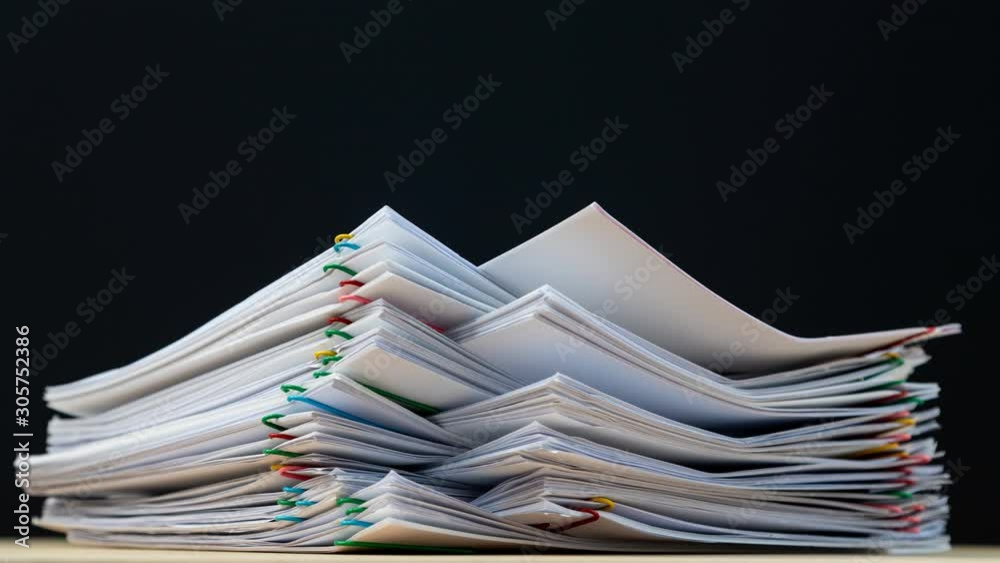Stack overload document report paper with colorful paperclip on black background, business concept footage paperless used – 4K Stop motion.