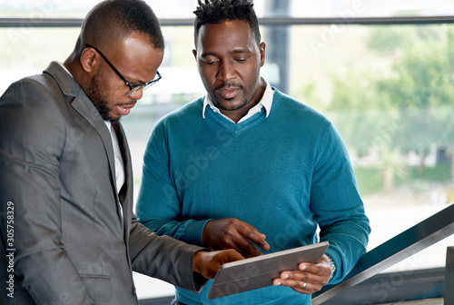 Two attractive black colleagues in bright modern office space wo