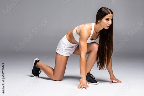 Beautiful young woman ready for run in workout clothes over white background