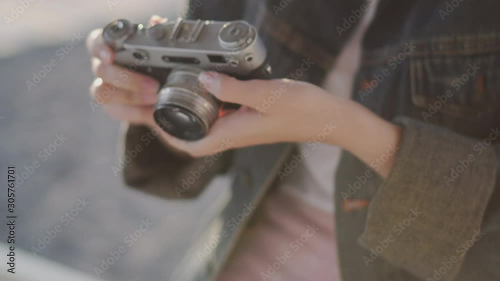 She is in a romantic mood by the sea with her camera while on vacation She is in a romantic mood by the sea with her camera while on vacation
