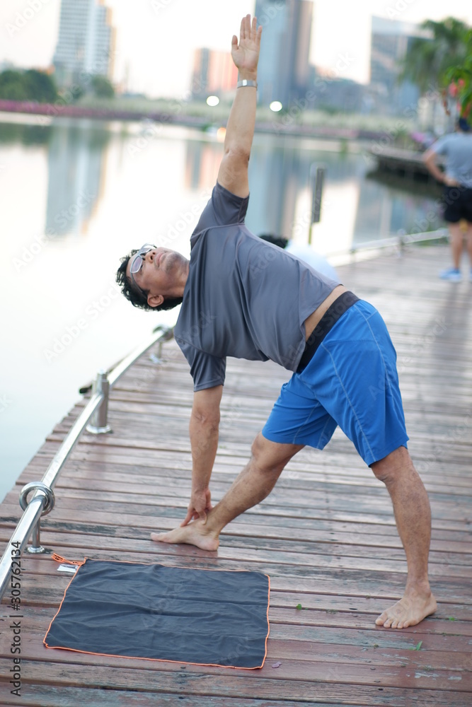 man on bridge​ doing yoga exercise flexible balance healthy