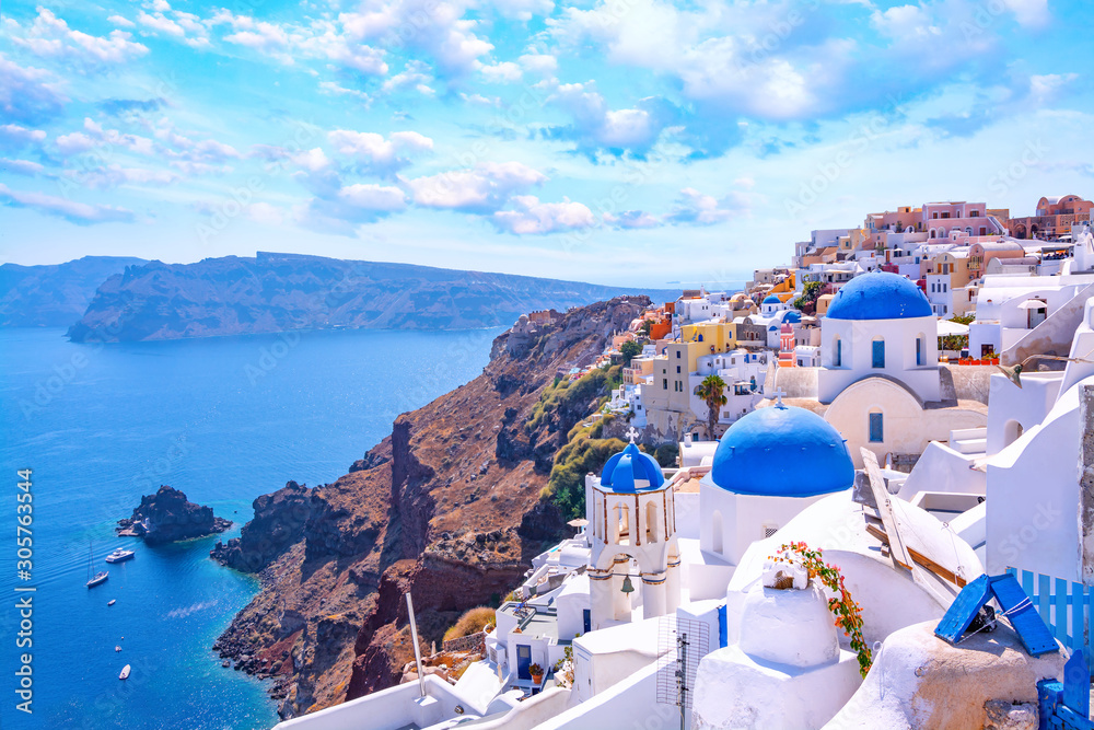 Obraz premium Piękne miasto Oia na wyspie Santorini, Grecja. Tradycyjna biała architektura i greckie cerkwie z niebieskimi kopułami nad kalderą na Morzu Egejskim. Malownicze tło podróży.