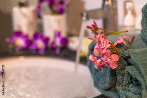 .pink flower on green towel in bathroom. photo