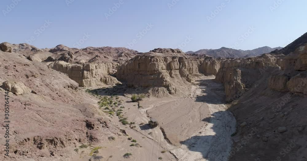 4K aerial view of a safari vehicle taking tourists sight seeing of old geological rock formations in the Namib desert, Namibia 4K aerial view of a safari vehicle taking tourists sight seeing of old geological rock formations in the Namib desert, Namibia