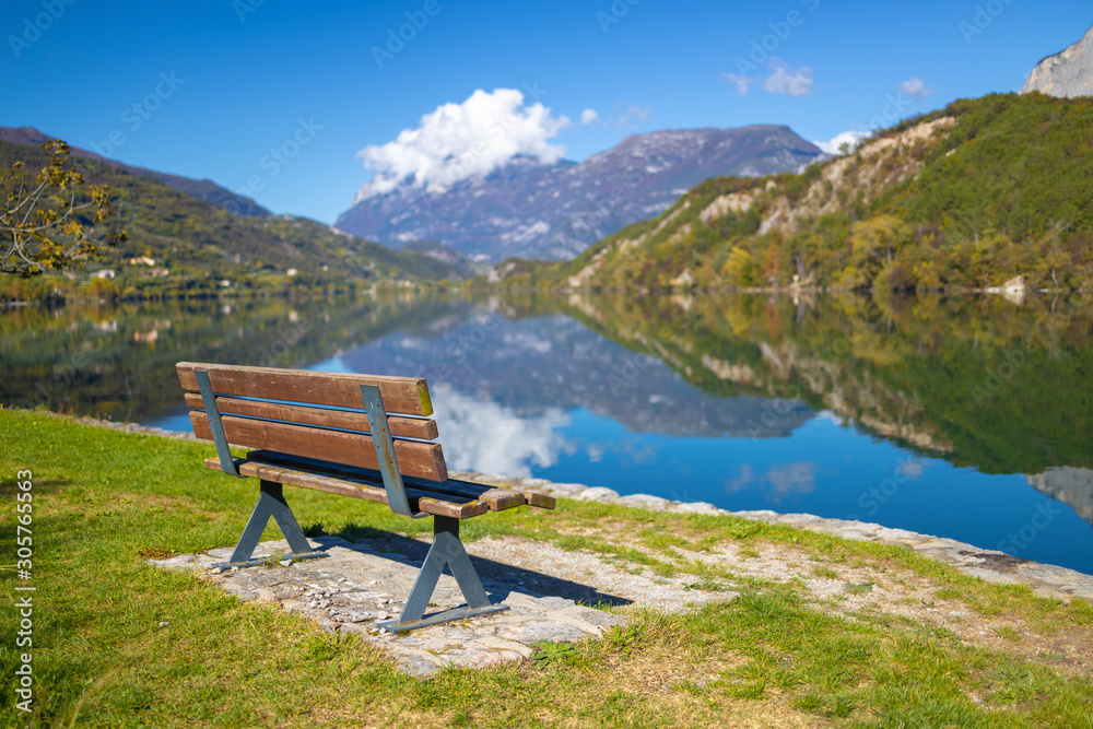 Lago di Cavedine beautiful lake. Wooden bench in focus. Italy. Arco