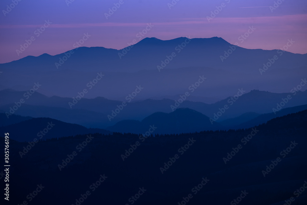 Obraz premium Colorful sunset over the mountain hills