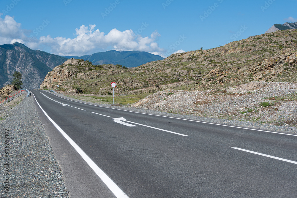 Asphalt road through hills and forest. Road trip in nature in mountains