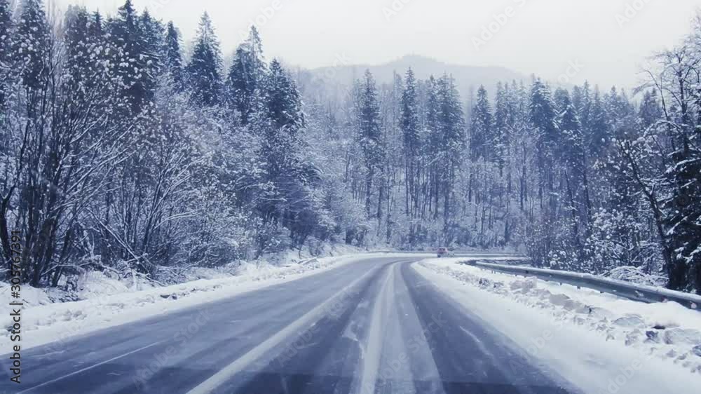 driving on the winter forest road in heavy snowfall, beautiful landscape