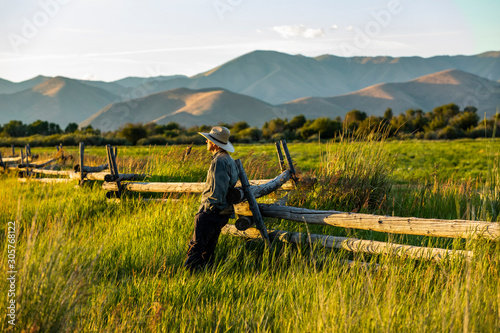 Farmer leaning on fence in Picabo, Idaho, USA