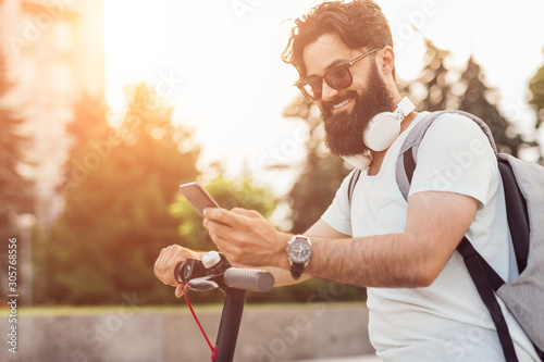 Cheerful hipster using smartphone during ride photo