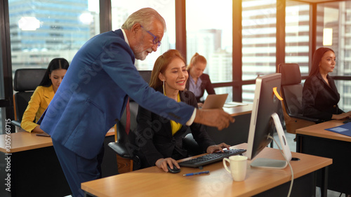 Senior employee discussing with business woman at workplace