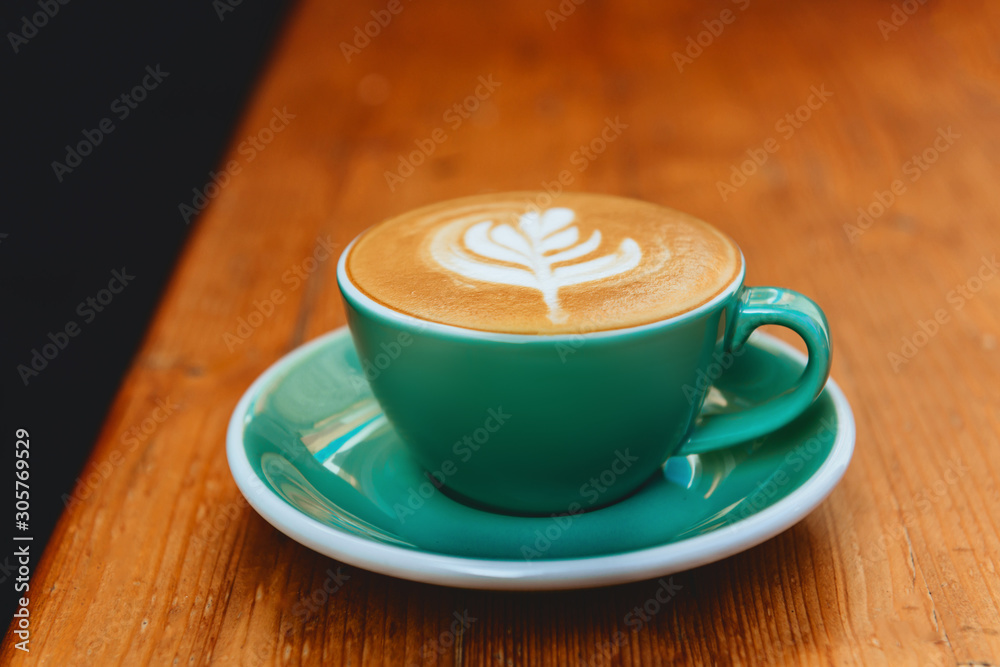 cup of cappuccino with latte art on wooden background. cup of cappuccino with latte art on wooden background.