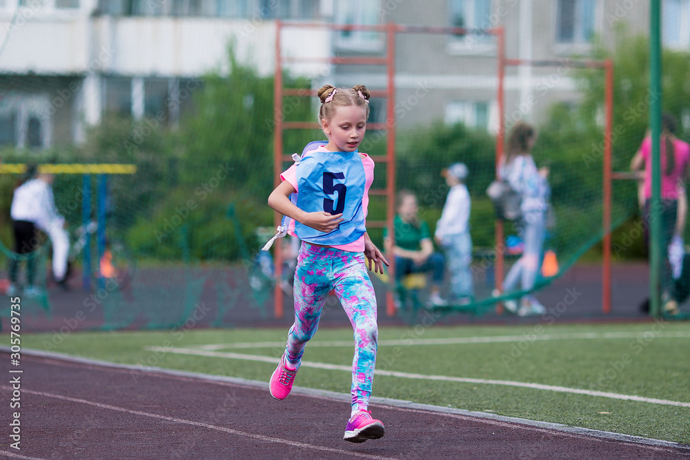 Cute happy girl athlete runs in the stadium in summer Cute happy girl athlete runs in the stadium in summer