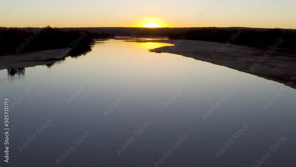 Aerial tilt-up view of the sun setting on a river in Gonarezhou National Park, Zimbabwe Aerial tilt-up view of the sun setting on a river in Gonarezhou National Park, Zimbabwe