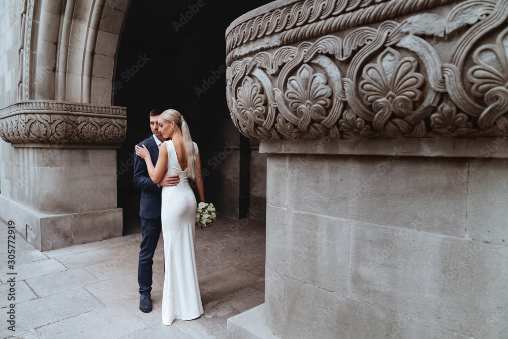 Happy bride and groom near old castle in wedding day Happy bride and groom near old castle in wedding day