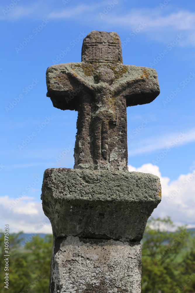 Jesus Christ sculpture on a medieval stone cross