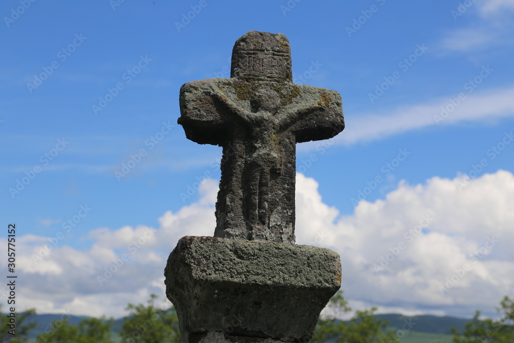 Jesus Christ sculpture on a medieval stone cross