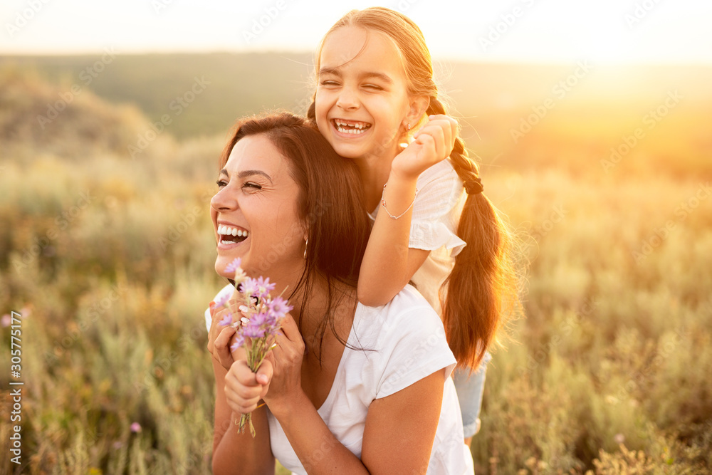 Happy mother and daughter resting at summer field - obrazy, fototapety, plakaty 