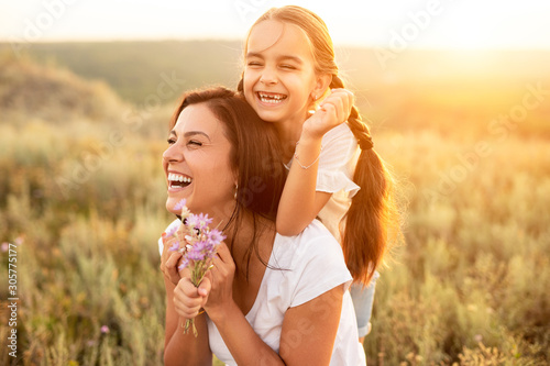 Stampa su tela Happy mother and daughter resting at summer field