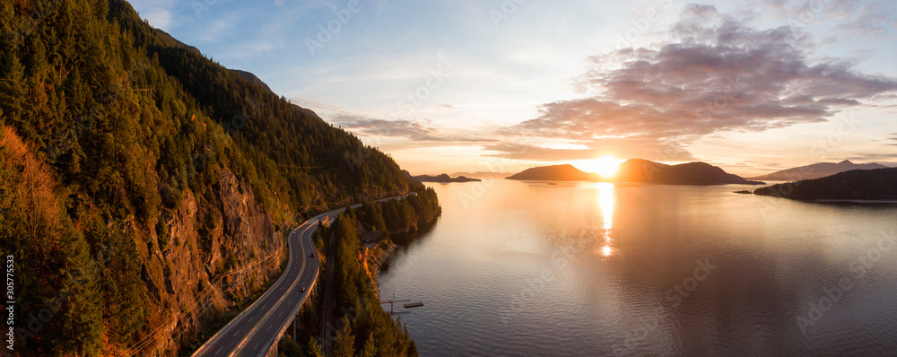 Fototapeta premium Sea to Sky Hwy w Howe Sound w pobliżu Horseshoe Bay, West Vancouver, British Columbia, Kanada. Panoramiczny widok z lotu ptaka podczas kolorowego zachodu słońca w sezonie jesiennym.