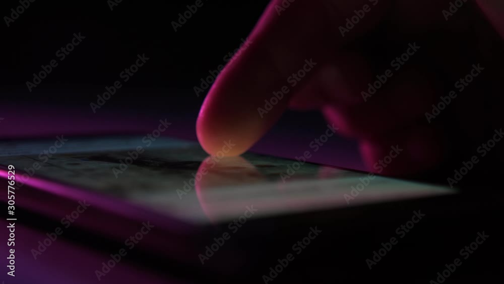 Man`s finger touching and scrolling a phone screen with Instagram information