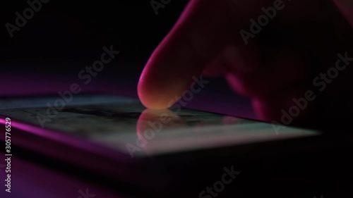 Man`s finger touching and scrolling a phone screen with Instagram information