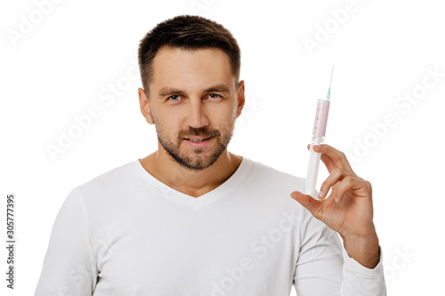 Portrait of handsome bearded man holding syringe on white background