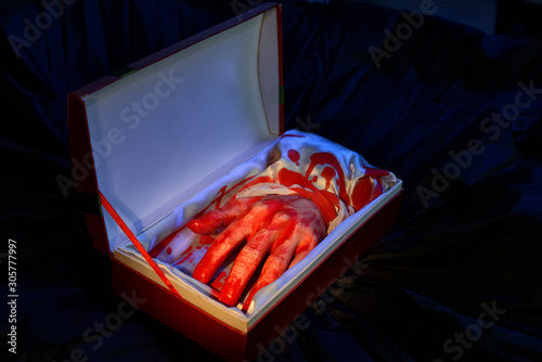 Cut bloody hand in open gift box. Blackmail, asking for ransom concept. Scary Halloween joke idea. BTW the hand is fake.