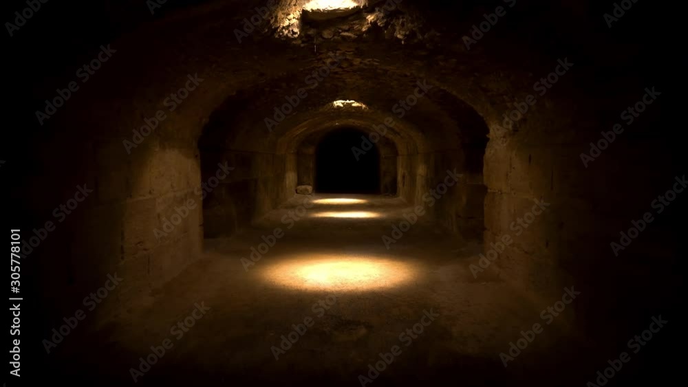 Pass through a long and dark Roman basement. Basement under the amphitheater in El Jem, Tunis. Ancient roman building. The camera is approaching