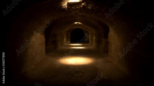 Pass through a long and dark Roman basement. Basement under the amphitheater in El Jem, Tunis. Ancient roman building. The camera is approaching