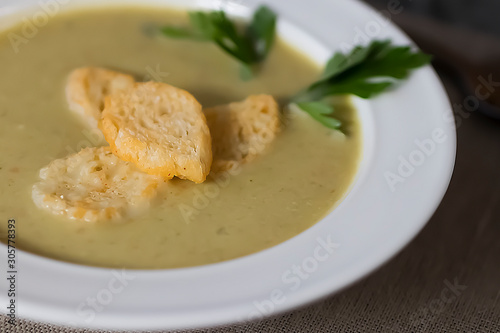 Cream of vegetable soup in a white bowl on a gray background.