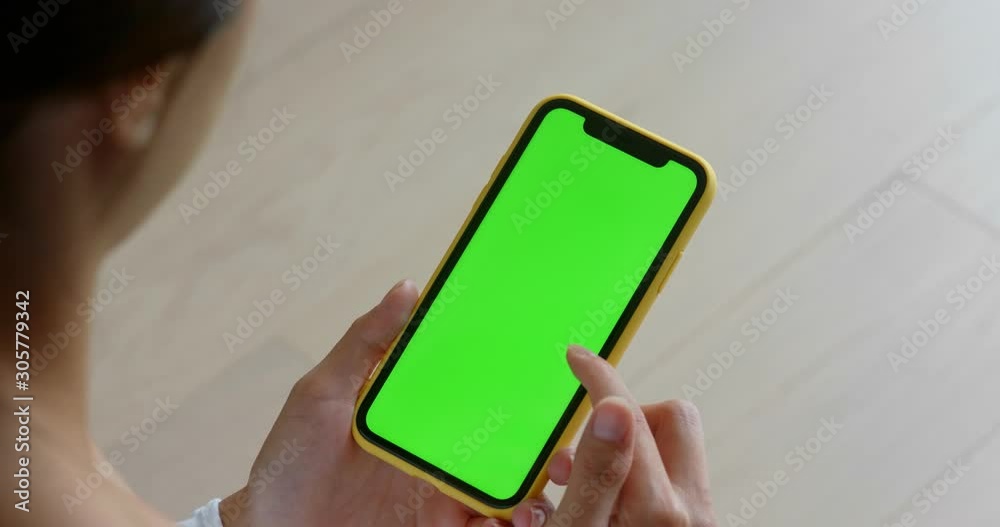 Woman use of green screen of mobile phone at home Woman use of green screen of mobile phone at home