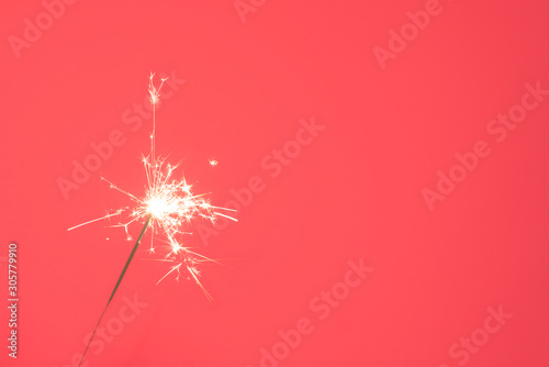 Canvas Print Close up of Brightly burning sparkler on a pink background.