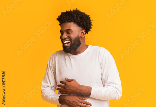 Funny african man laughing out loud, holding his belly