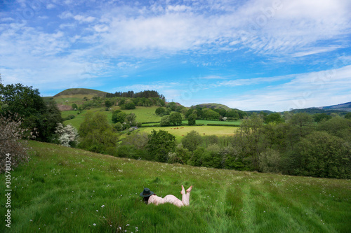 Naked Woman lying in a meadow, Cambrian Mountains, Wales, UK photo