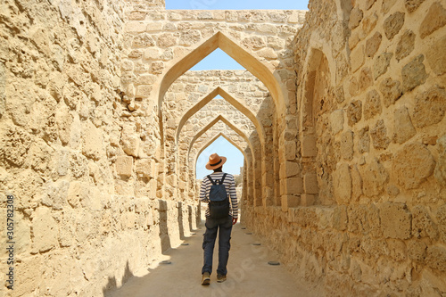 Man Walking along the Archways in Ancient Bahrain Fort, Manama, Bahrain 