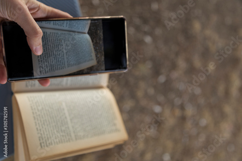 the woman use Samsung note 9 mobile phone to read book.