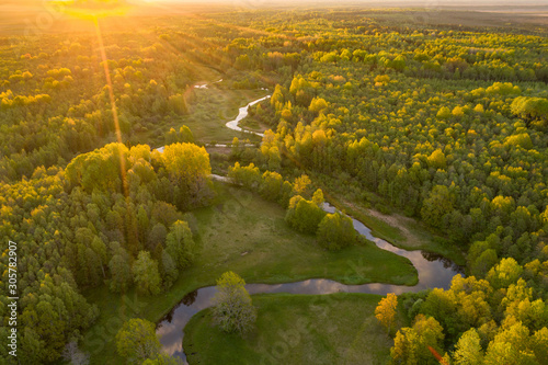 Forest in summer colors. Green deciduous trees and winding blue river in sunset. Mulgi meadow, Estonia, Europe photo