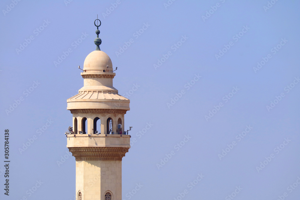 Minaret of the mosque against sunny sky