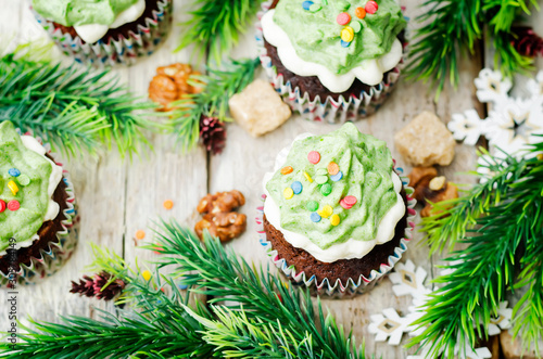 Chocolate cupcakes with green frosting and sprinkles on holiday
