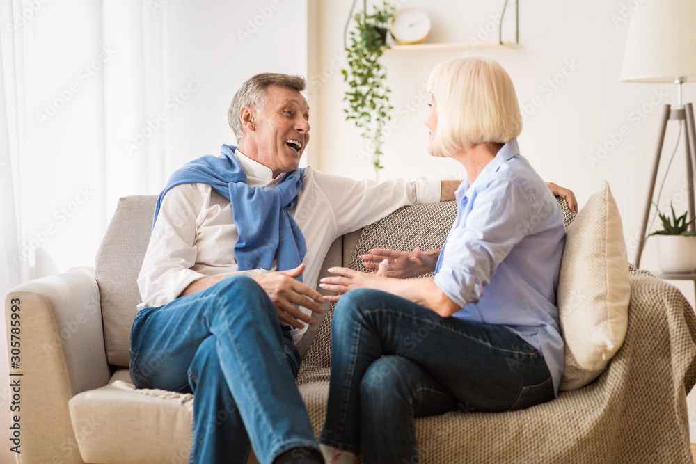 Happy senior spouses talking, enjoying conversation and joking