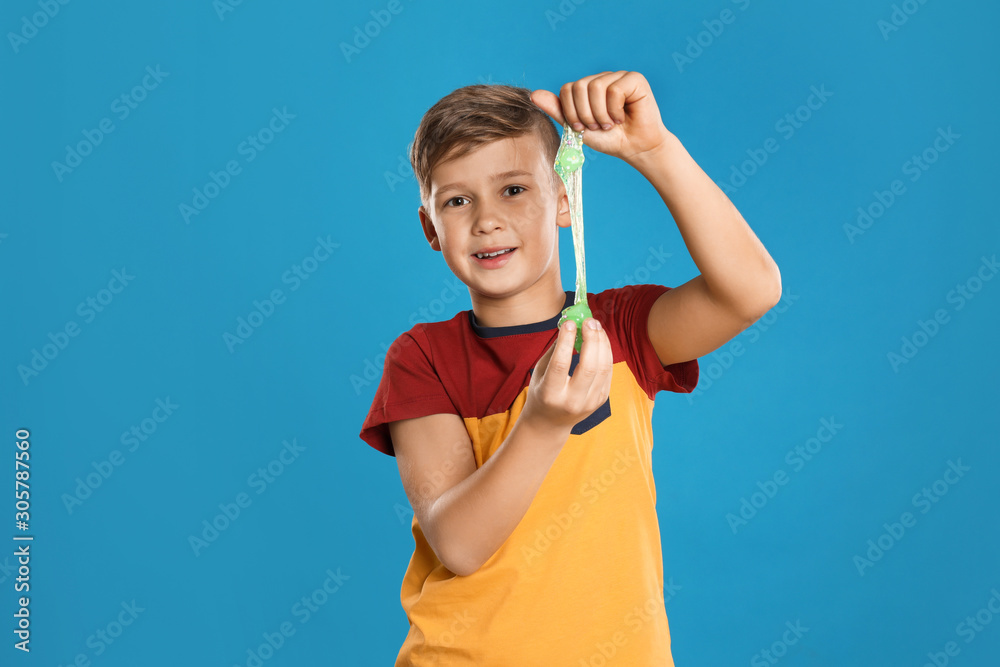 Preteen boy with slime on blue background Preteen boy with slime on blue background